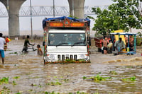 | Photo: PTI : Vehicles pass through a waterlogged road in Patna