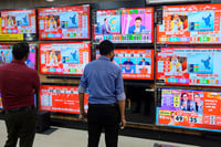 | Photo: PTI : Assembly election results day: People at TV showroom