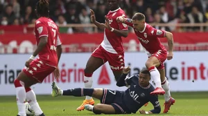 PSG's Kylian Mbappe, on the pitch, is tackled by Monaco's Ruben Aguilar during their Ligue 1 match.