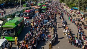 Crowds of Indian migrant workers wait to board buses during Covid-19 lockdown.