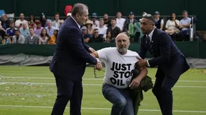 A Just Stop Oil protester is escorted off Court 18 by security on Wednesday.