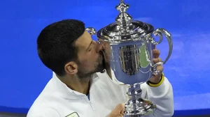 Novak Djokovic kisses championship trophy after defeating Daniil Medvedev.