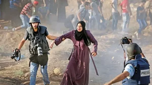 Caught in the Crosshairs: A press photographer rescues a woman from tear gas at a protest in Gaza