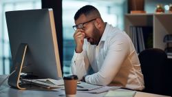 Shot of a young businessman experiencing stress during late night at work