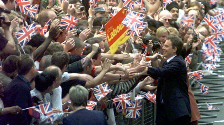 FILE - In this Friday May 2, 1997 file photo, Britain's new Prime Minister Tony Blair, is greeted by a sea of flag-waving well-wishers in Downing Street. Blair's Labour Party won a landslide victory against the Conservatives in a General Election to end 18-years of Conservative rule. Twenty years on, opinion polls point to a big Labour defeat at the June 8, 2017 election. (AP Photo/Adam Butler, File)