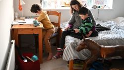 Seven-year-old Leo (L), and four-year-old Espen (R) are watched by their mother Moira as they complete their remote learning tasks, set by their local primary school after they were made to close due to COVID-19, in Marsden, northern England on January 21, 2021. - Schools and colleges across Britain closed on January 5, ahead of a national lockdown as the country battles to control surging coronavirus cases that are threatening to overwhelm its healthcare system. (Photo by Oli SCARFF / AFP) (Photo by OLI SCARFF/AFP via Getty Images)