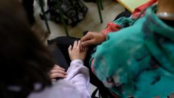 Two teenagers touch each other's hands during interactive theatre by El Teatro Que Cura (The Healing Theatre) to raise awareness about domestic violence among teens, at El Olivo high school in Parla, south of Madrid on November 11, 2022. - Set up in 2017, Teatro que Cura uses interactive theatre to immerse teens in dramatised scenarios of inequality and violence to raise awareness about conflict and gender-based violence. (Photo by OSCAR DEL POZO / AFP) (Photo by OSCAR DEL POZO/AFP via Getty Images)