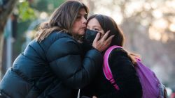 A mother kisses her daughter goodbye outside the Sagrado Corazon school on Santiago on June 14, 2023, as Chile reinstated the use of masks in schools due to a strong outbreak of a respiratory virus. Students in Chile must once again use masks in schools as a preventive measure against the "largest" outbreak of the respiratory syncytial virus (RSV) since the country has registered it, the Ministry of Health announced on June 13. (Photo by Pablo VERA / AFP) (Photo by PABLO VERA/AFP via Getty Images)