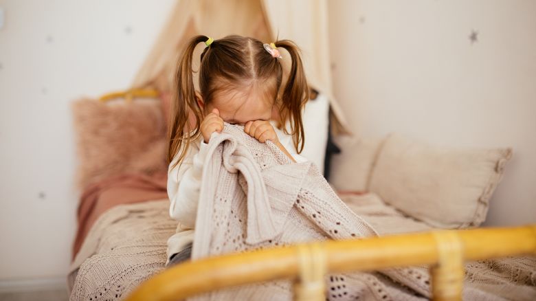 Portrait of unhappy small girl indoors, crying.