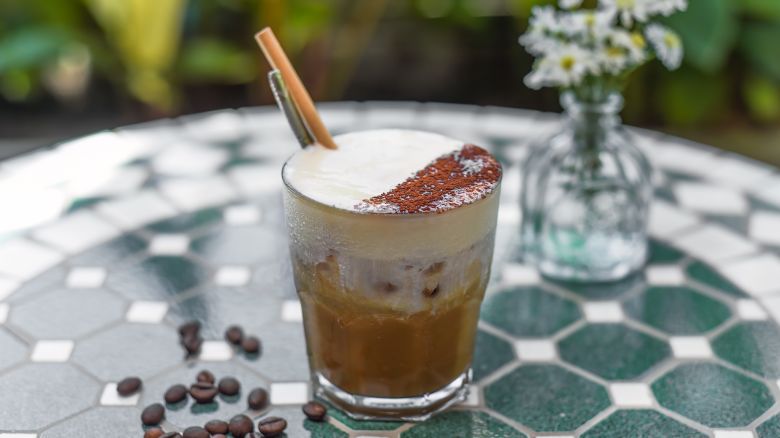 Vietnamese salted coffee with salty cheese cream (ca phe muoi) against green leaves