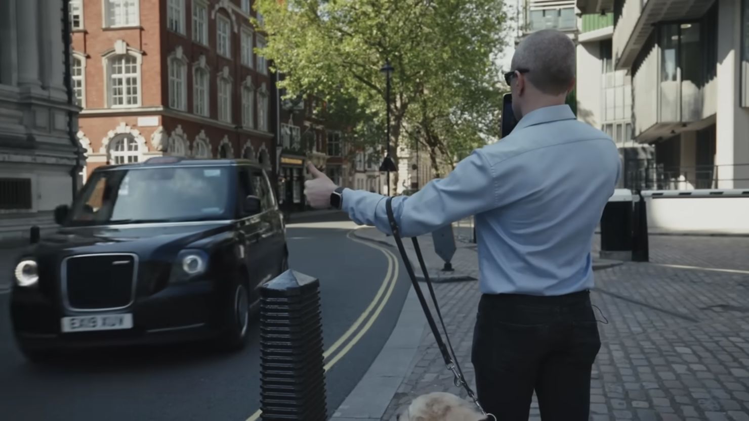 This screen grab from a video posted on YouTube by OpenAI and Be My Eyes shows a person using an AI-powered version of Be My Eyes to hail a taxi.