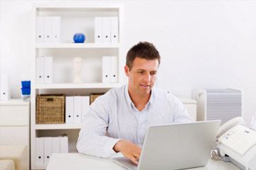 Business man working on laptop computer at home.