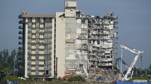 A Miami building is evacuated near the site of the deadly Surfside condo collapse