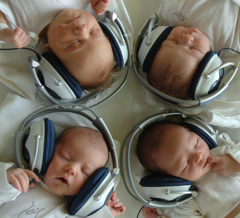 Newborn babies listen to music with headphones.