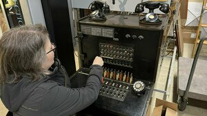 A visitor at the Connections Museum works the kind of switchboard system that first connected American phone users.