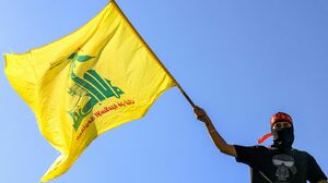 A masked demonstrator waves a flag of Hezbollah during a demonstration supporting the Palestinians in Beirut on Oct. 20, 2023.