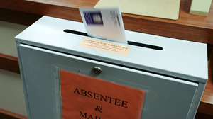 A citizen deposits a ballot into a box at the county clerk's office in Erie, Pa., on Oct. 15, 2020.