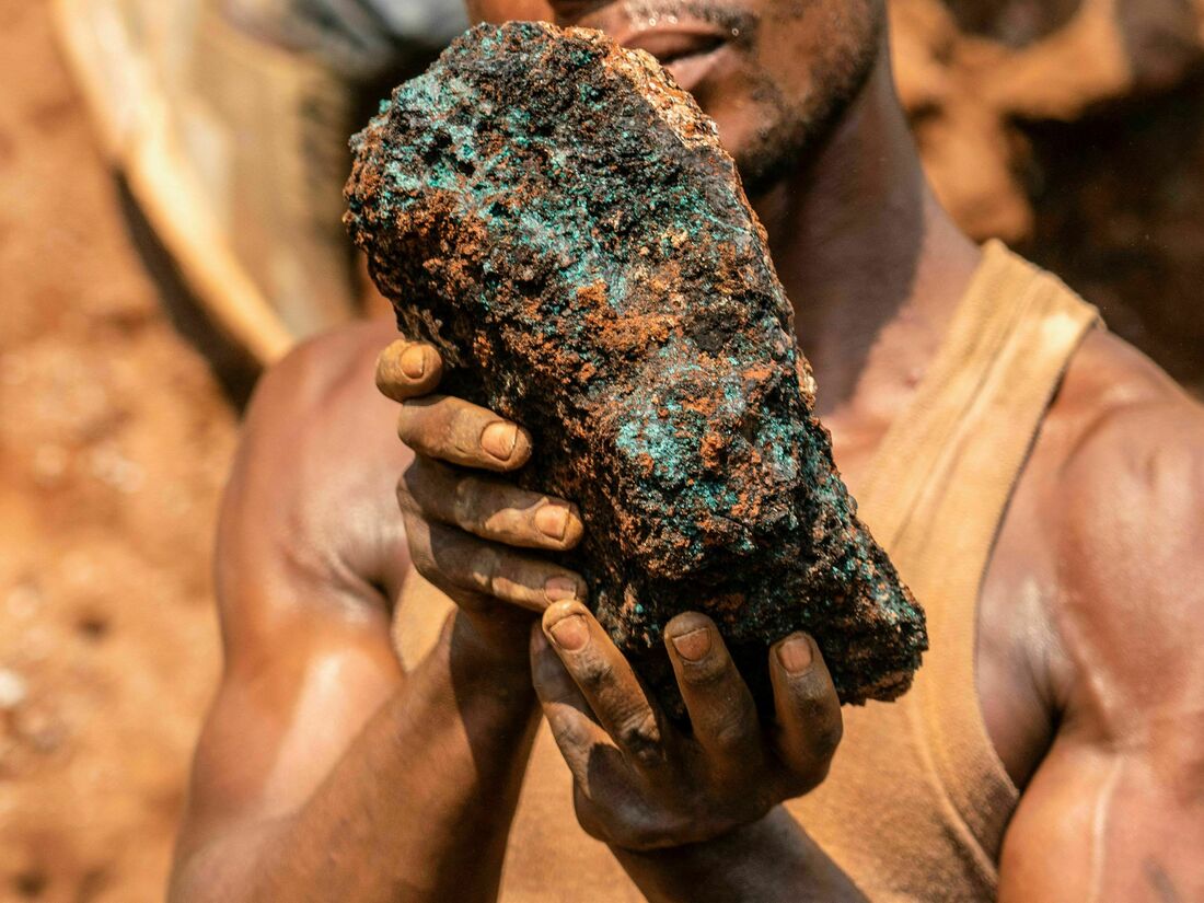 Dela wa Monga, an artisanal miner, holds a cobalt stone at the Shabara artisanal mine near Kolwezi on October 12, 2022. - Some 20,000 people work at Shabara, in shifts of 5,000 at a time. Congo produced 72 percent of the worlds cobalt last year, according to Darton Commodities.