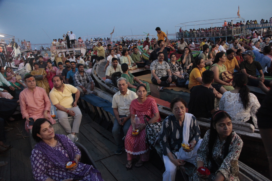 Worshippers and tourists sit on boats facing the bank of the Ganges River in the holy Hindu city of Varanasi to watch the Ganga Aarti, a ritual of devotion to the venerated river.