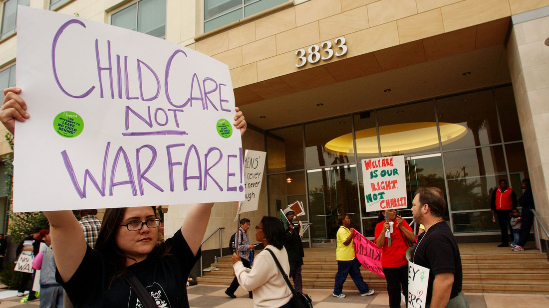 LOS ANGELES - OCTOBER 15: A woman holds a sign reading "Childcare Not Warfare" during an anti-war protest October 15, 2002 in Los Angeles, California.