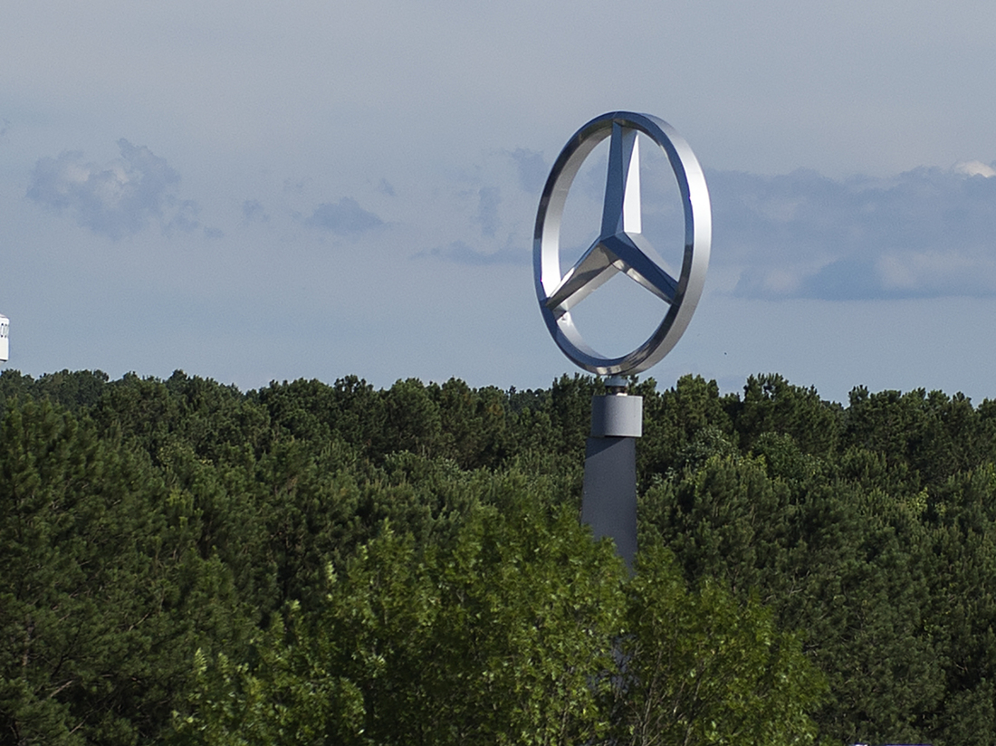 A giant Mercedes-Benz logo towers over the tree line at the Mercedes-Benz U.S. International plant in Vance, Ala., on June 7, 2017.