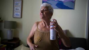 Jackye Lafon, who's in her 80s, cools herself with a water spray at her home in Toulouse, France during a heat wave in 2022. Older people face higher heat risk than those who are younger. Climate change is making heat risk even greater.