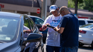Poder Latinx canvasser Humberto Orjuela helps Andres Navarro register to vote in a Presidente Supermarket parking lot in Orlando on April 20. New restrictions in Florida have made voter registration work more difficult for Poder Latinx and other third-party groups.