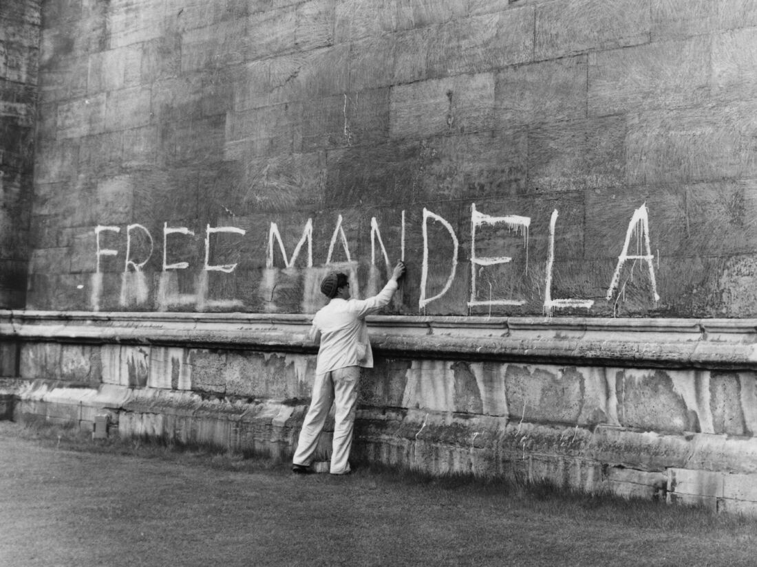A man washing a 'Free Mandela' slogan off the side of King's College Chapel, Cambridge.