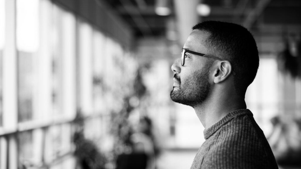 Profile view of a male looking out a window