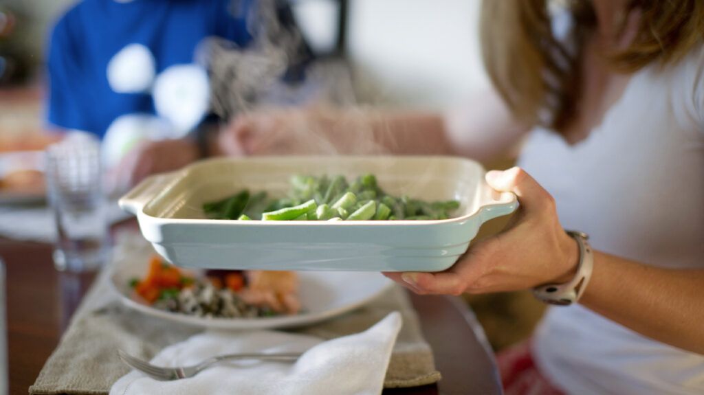 female passing green beans