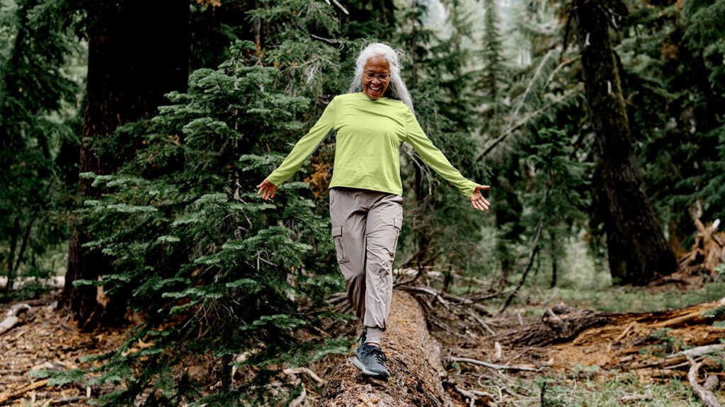 An older woman in workout clothes goes on a hike in the forest