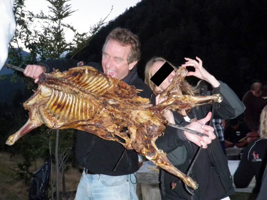 RFK Jr. posing alongside an unidentified woman with the barbecued remains of what appears to be a dog.