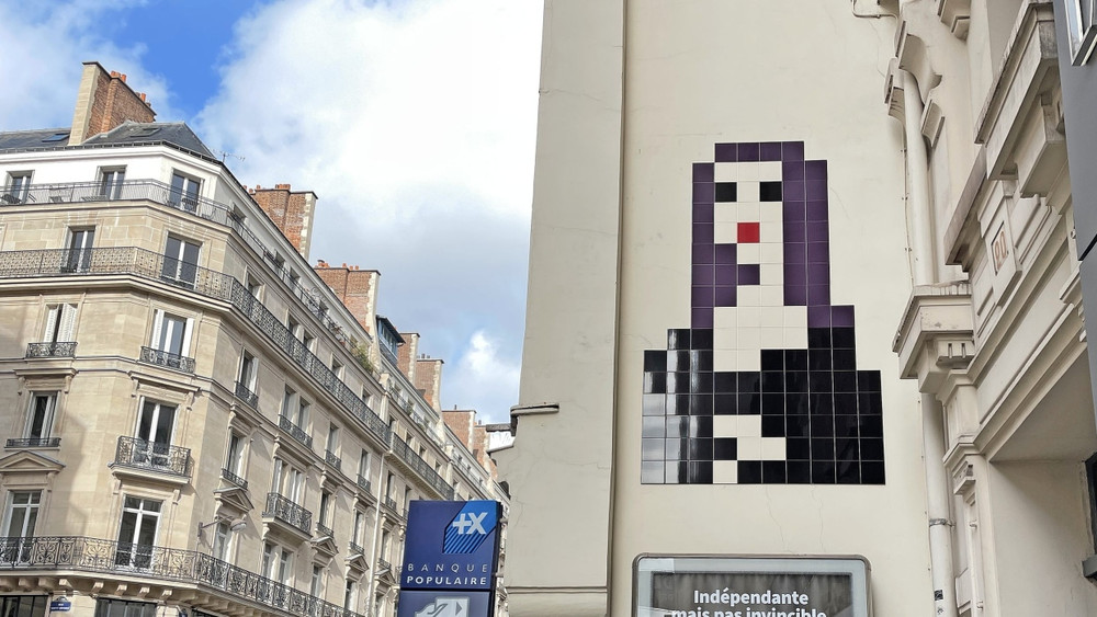 100 Punkte! Invaders Mona Lisa in Paris, zusammengesetzt aus 88 schwarzen, lilafarbenen und einer roten Kachel.