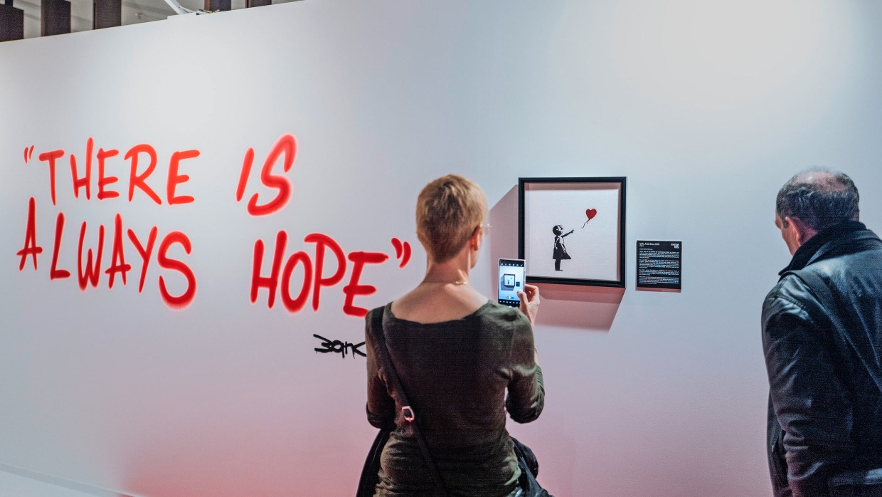 Frau mit Mädchen mit Ballon: Besucher in der Ausstellung „The Art of Banksy“ in Frankfurt.