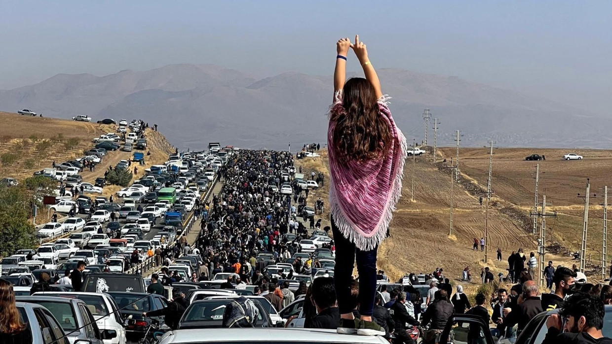 Eine Frau steht während der Frau-Leben-Freiheit-Proteste 2022 auf einem Auto im Westen Irans.