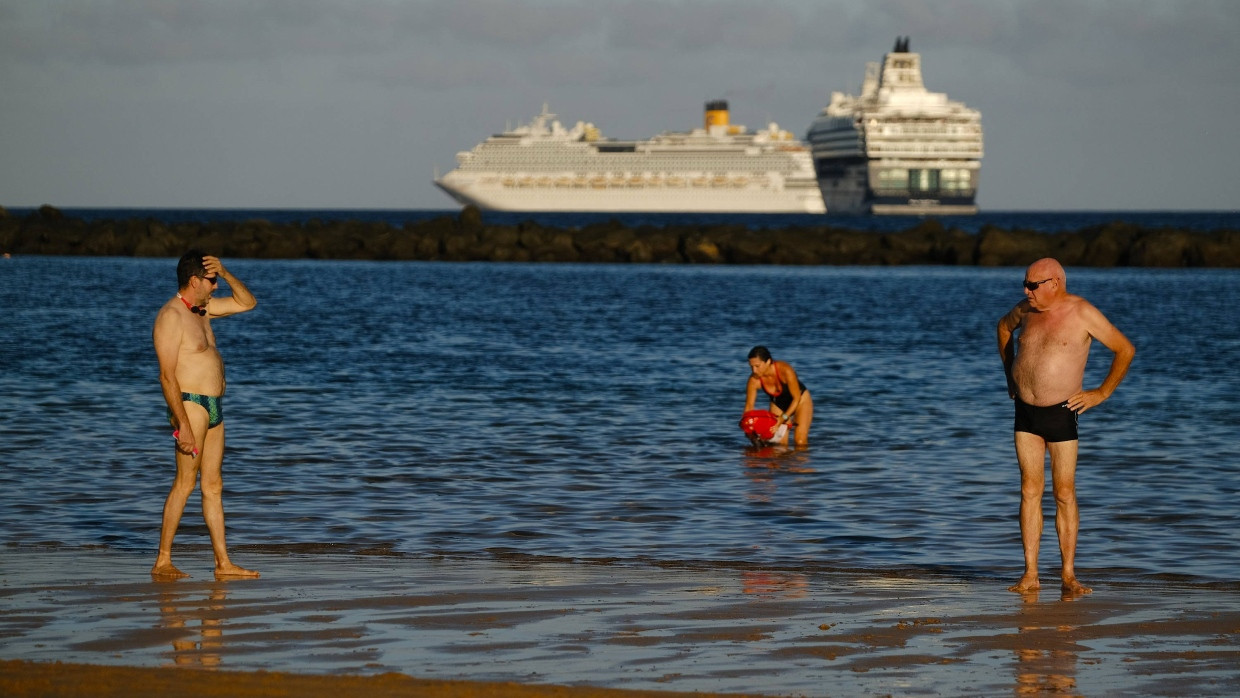 Nur wenige Urlauber baden am Strand La Teresita in Santa Cruz, Teneriffa.