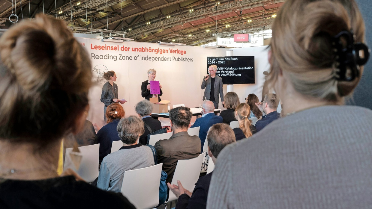 Zusammenhalt: Katharina Meyer (Mitte) stellt auf der Leseinsel der unabhängigen Verlage in Halle 3.1 den Katalog der Kurt Wolff Stiftung vor.