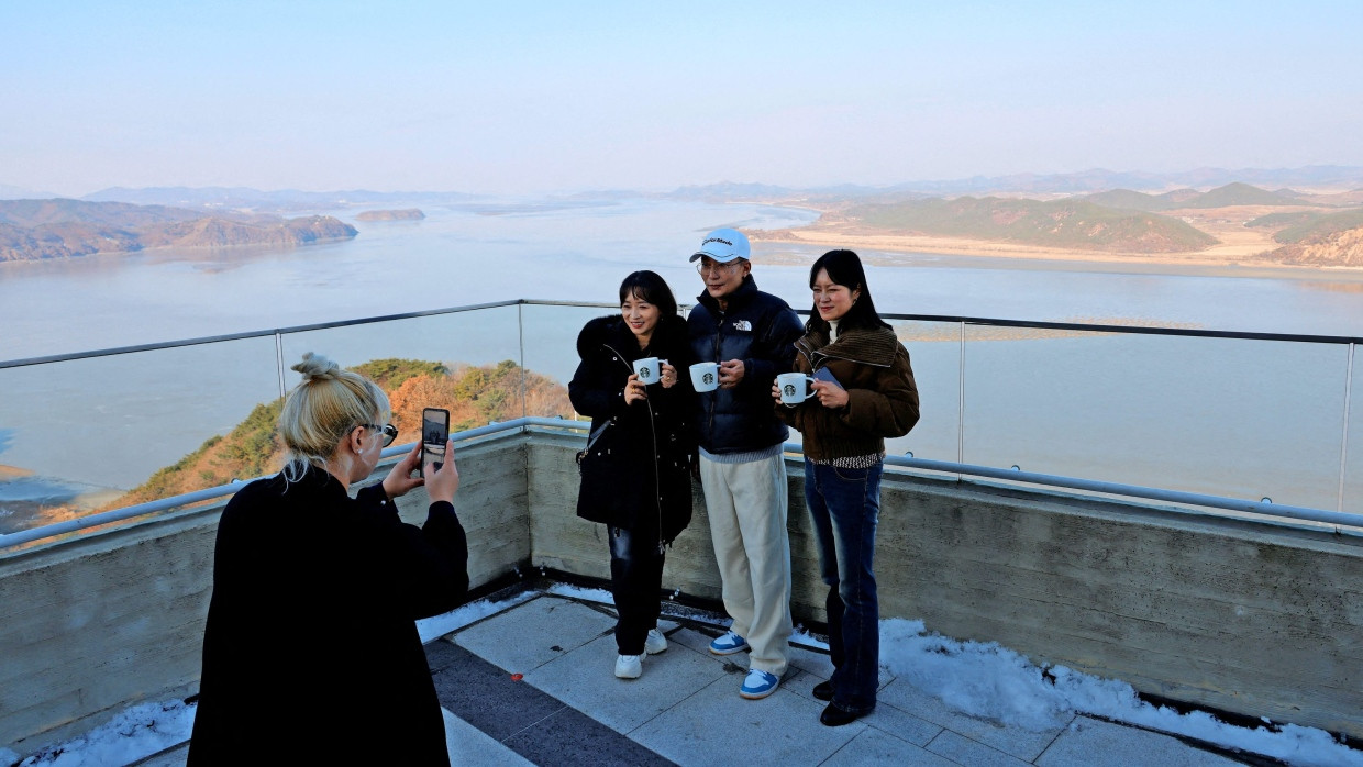 Prost Kaffee! Starbucks-Gäste am Aegibong Peak Observatory lassen sich am Freitag vor nordkoreanischer Kulisse fotografieren.