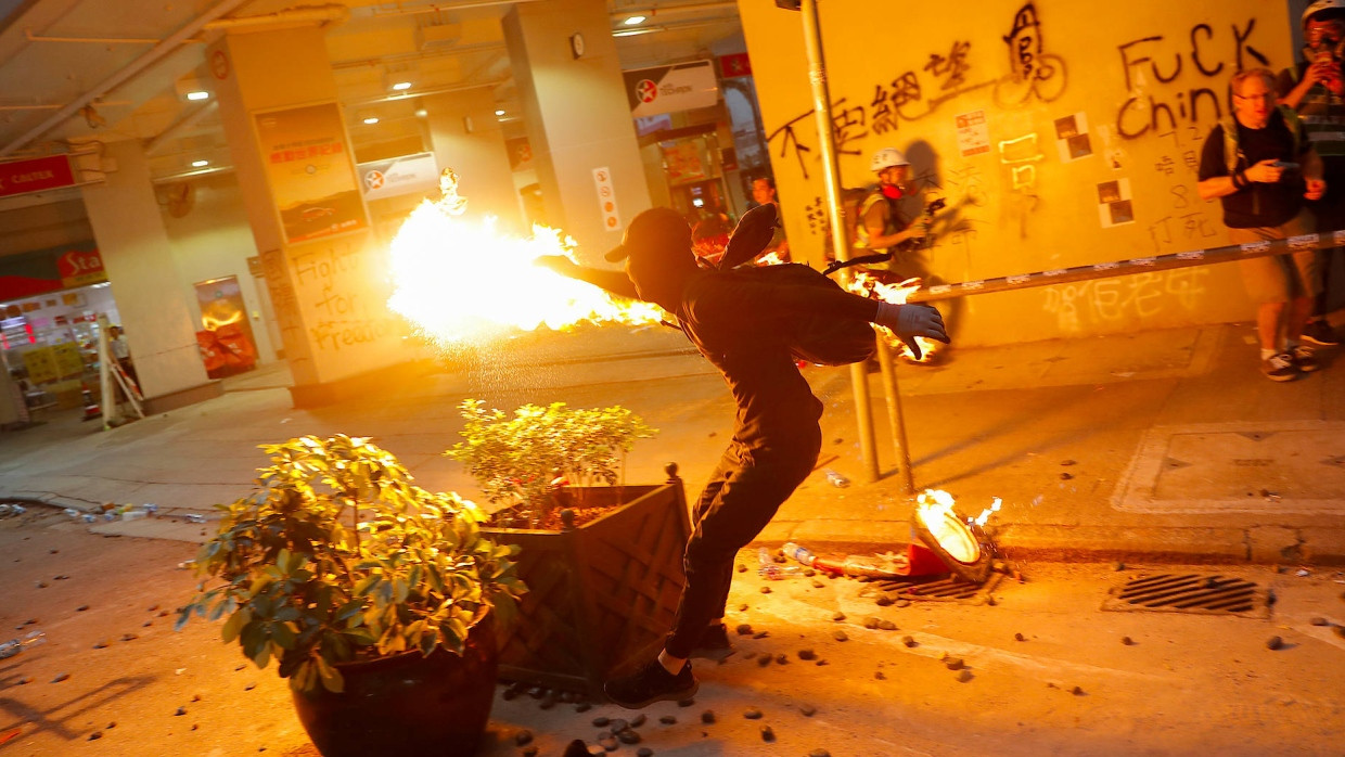 Ein Demonstrant wirft bei Protesten während des chinesischen Nationalfeiertags einen Molotow-Cocktail.