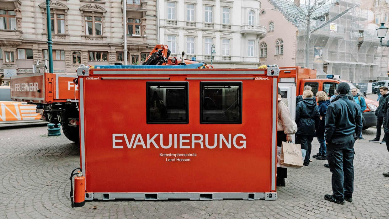 Üben für die Notlage: Eine Evakuierungskabine dient im Notfall als Ansprechstelle für die Bevölkerung. Timo Umstädter von der Wiesbadener Feuerwehr erklärt, wie die Starlink-Antenne funktioniert.