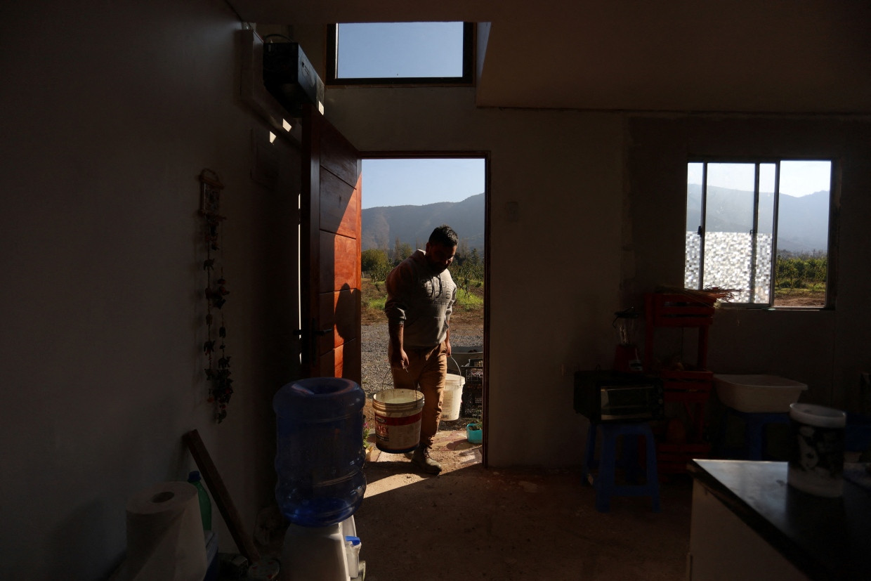 Ein Bauer trägt Wasser in sein Haus. Mehr als eine Million Menschen leiden in Chile unter der Wasserknappheit.