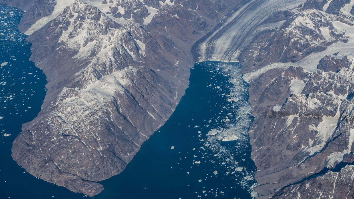 Kalbender Gletscher und Eisschollen in einem grönländischen Fjord.