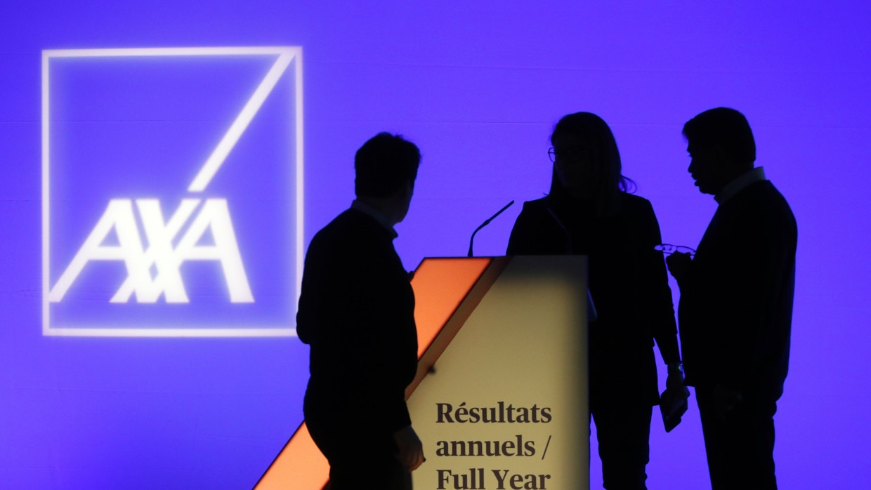 Menschen stehen vor einem Schild des französischen Versicherungskonzerns AXA.