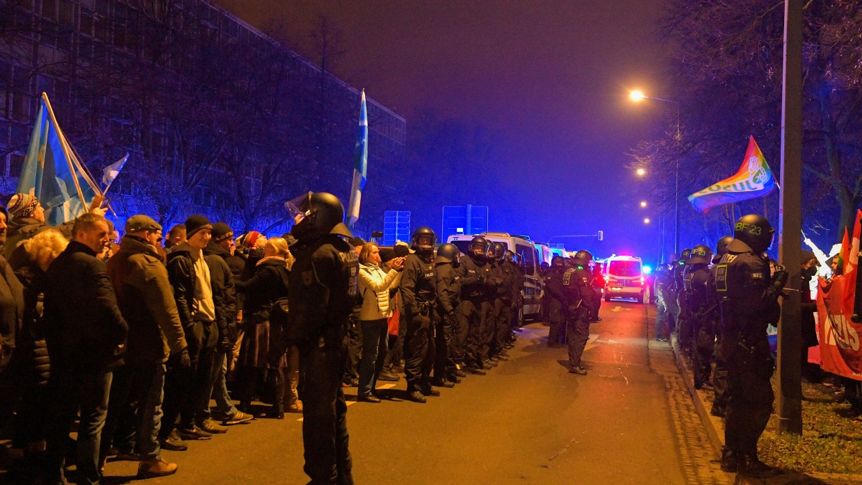 Polizisten trennen die Teilnehmer von zwei Demonstrationen voneinander.