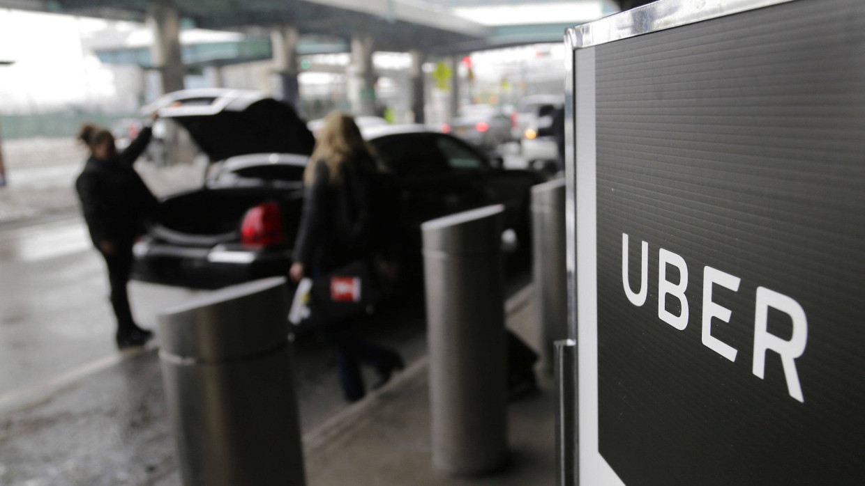 Ein Schild mit dem Logo des amerikanischen Dienstleistungsunternehmens Uber am Abholpunkt von Uber auf dem LaGuardia-Flughafen in New York.