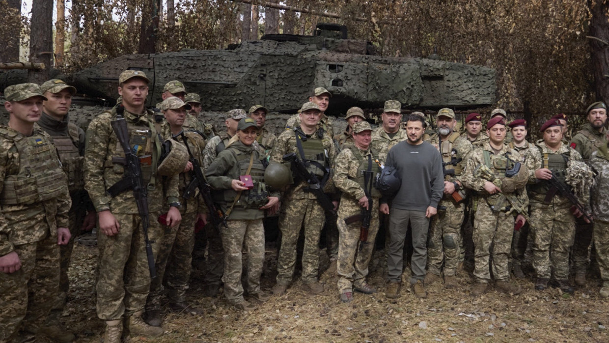 Der ukrainische Präsident Wolodymyr Selenskyj posiert bei seinem Truppenbesuch mit Soldaten vor einem Leopard-2-Kampfpanzer.