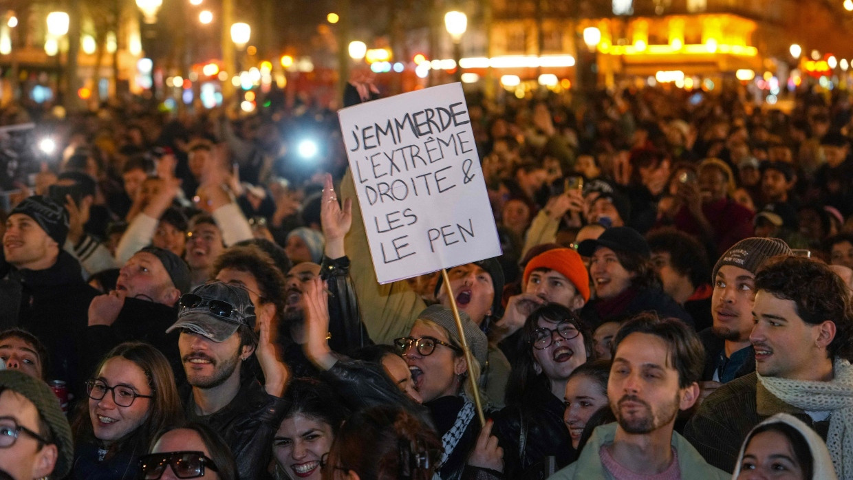 Eine Frau hält am Place de la Republique ein Plakat mit der Aufschrift: „Zum Teufel mit den Rechtsextremen und den Le Pens“