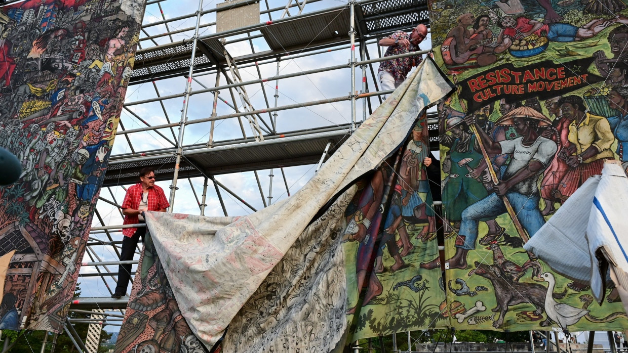 Documenta-Mitarbeiter entfernt am 21. Juni 2022 einen Teil des umstrittenen Großbanners „People's Justice“ des indonesischen Künstlerkollektivs Taring Padi auf dem Friedrichsplatz. Die Installation auf der documenta fifteen in Kassel war als eindeutig antisemitisch kritisiert worden.