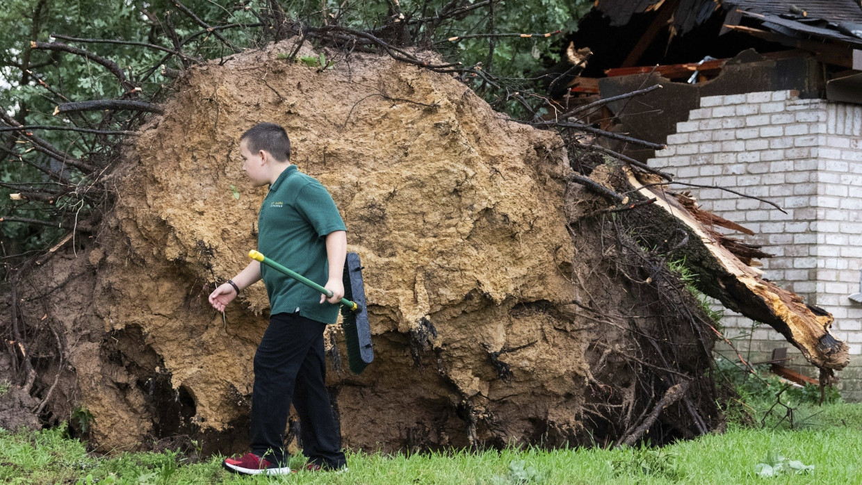 Ein Junge läuft durch einen Garten in Houston, wo ein Baum durch den Tornado aus dem Boden gerissen wurde.