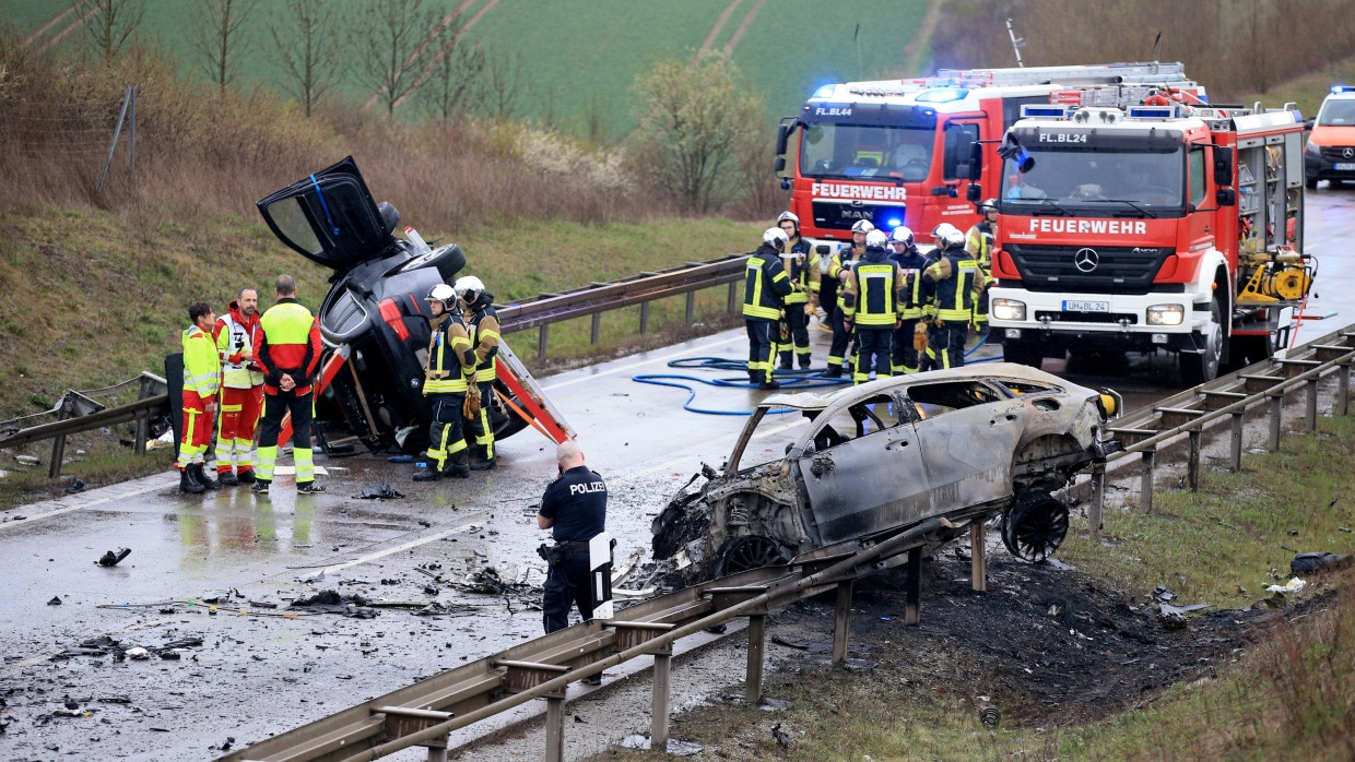 Ein ausgebrannter PKW und ein weiteres verunfalltes Fahrzeug stehen an der Unfallstelle auf der B 247 bei Bad Langensalza in Thüringen.